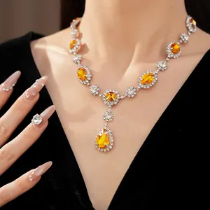 Close-up detail of a silver necklace featuring yellow water-drop stones and rhinestones