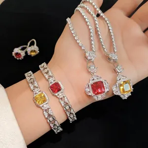 Elegant silver-tone jewelry set with square red and yellow zircon stones on a dark background.