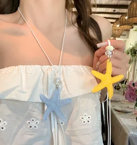Detail view of colorful starfish necklaces in blue and yellow for beach vacation style.
