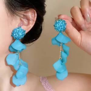 Close-up of vibrant blue acrylic flower petal tassel earrings for a summer look.