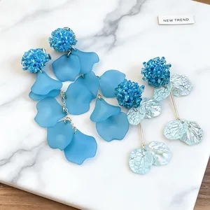 Close-up of blue frosted petal earrings and pearlized flower dangles