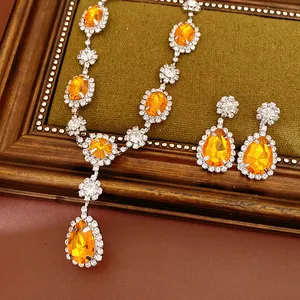 Close-up of vintage jewelry set with orange teardrop gemstones and rhinestones