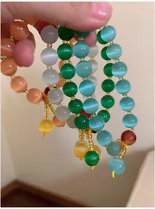 Vue détaillée de bracelets de perles en œil de chat colorés avec pendentifs à glands