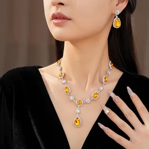 Elegant yellow rhinestone jewelry set featuring teardrop necklace and earrings on model