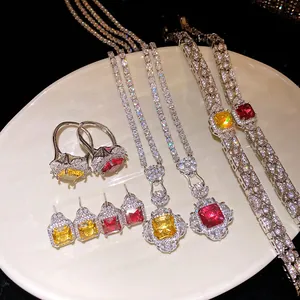 Detailed set of silver zircon jewelry with square yellow and red stones on a cream dish