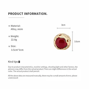 Vintage goudkleurige ring met rode harssteen en productinformatie.