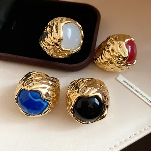 Macro-opname van vintage goudkleurige ringen met diverse gekleurde harsstenen.