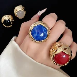 Detailopname van vintage gouden ringen met levendige blauwe en rode harsstenen