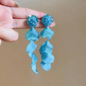 Close-up of blue acrylic petal tassel earrings with textured floral studs