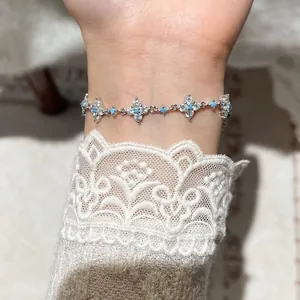 Elegante bracciale a fiore in zircone con perline turchesi blu su un polso femminile