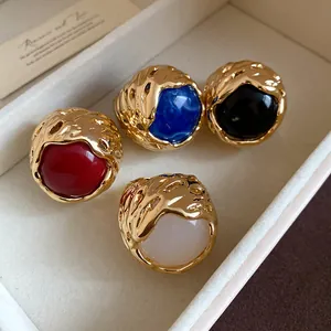 Macrodetail van vintage harsringen in rood, blauw, zwart en wit goudkleurige zetting.