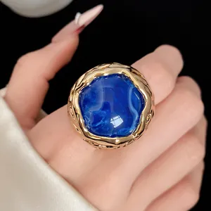 Gedetailleerde macro-weergave van een vintage blauwe harsring met gouden structuur