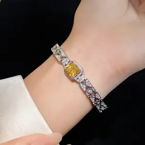 Close-up of elegant silver bracelet with square yellow zircon and pavé butterfly links