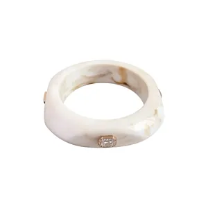 Elegant marble pattern resin bangle with square rhinestone inlay in gold tone setting