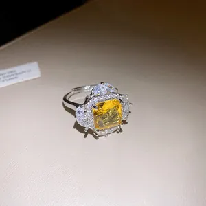 Detail view of a luxury silver open ring featuring a radiant square yellow zircon gemstone.