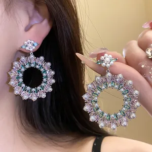 Close-up view of elegant floral wreath earrings with pink zircons and white pearls