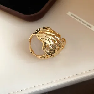 Gedetailleerde close-up van de gouden lavatectuur en witte hars op deze vintage ring