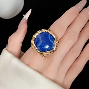 Macro-opname van een vintage goudkleurige ring met een koningsblauwe harssteen detail