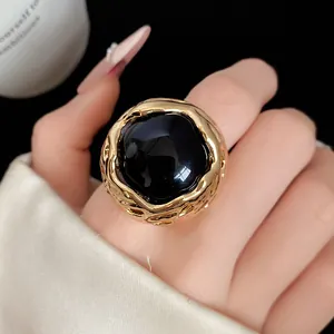 Detailopname van een vintage gouden ring met een grote zwarte harssteen in hofstijl