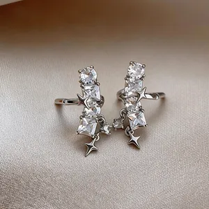 Close-up of silver-tone star ear clips featuring sparkling square and round CZ stones