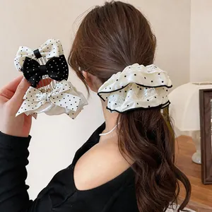 Dettaglio di fermagli per capelli con fiocco a pois e elastico in un'acconciatura.