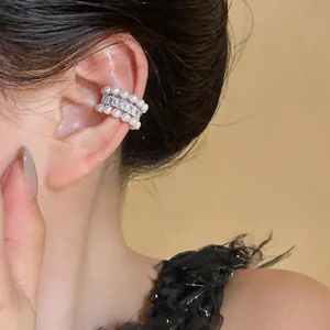 Dettaglio macro di un elegante polsino per orecchie con zirconi e perle senza buco