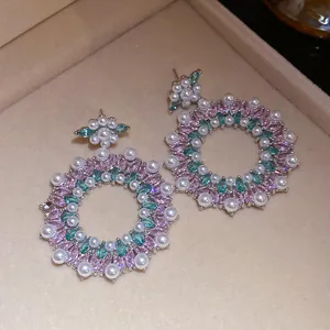 Elegant close-up of floral design earrings featuring pink zircons and white pearls