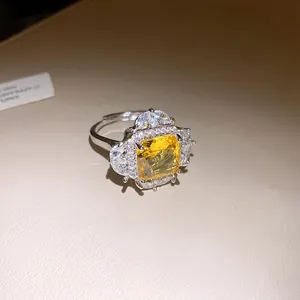 Close-up of elegant square yellow zircon ring with halo diamond setting for women