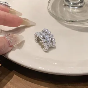 Dettaglio ravvicinato di un ear cuff argento con perle eleganti e zirconi brillanti