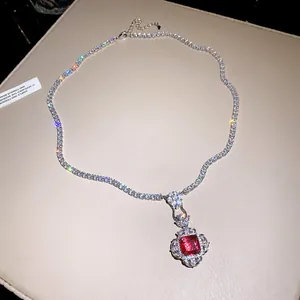 Detailed view of an elegant tennis necklace with a square red gemstone floral pendant.