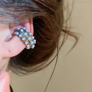 Close-up of vintage C-shaped ear cuff with multi-color rhinestones and pearls