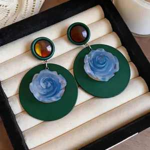 Vintage French style dark green resin hoop earrings with blue rose center in cream tray