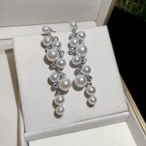Close-up detail of elegant white resin pearl drop earrings with sparkling rhinestones