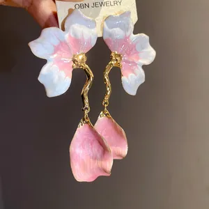 Detail shot of the elegant pink and white drip oil flower earrings with petal drops