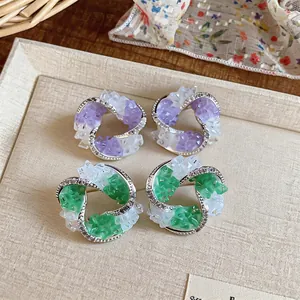 Macro shot of elegant geometric stud earrings with glass stones and zircon accents