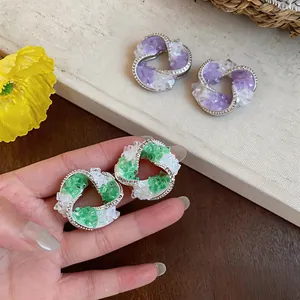 Detail view of geometric earrings with colorful crushed glass and sparkling zircons.