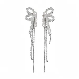 Elegant silver tassel earrings with lace bow design, pearls, and sparkling zircons.