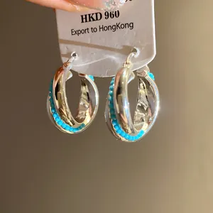Close-up of elegant silver-toned hoop earrings with turquoise blue bead detailing