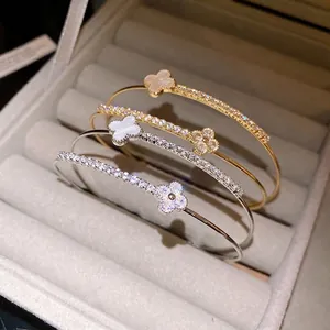 Four-leaf clover open bangles with sparkling cubic zirconia in a luxury jewelry box