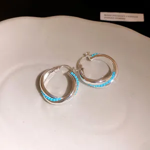 Detailed close-up view of elegant silver-toned hoop earrings with turquoise beads inlay