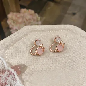 Detailed macro view of elegant rose gold clip-on earrings with pink cat eye stones