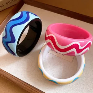 Bracelets rétro en résine avec motifs de lignes ondulées dans un plateau en bois