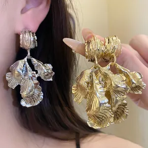 Detailed view of gold and silver textured leaf earrings showing fine metallic surface texture