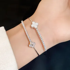 Close-up of a double-layered silver bangle featuring exquisite zircon-set clover charms.