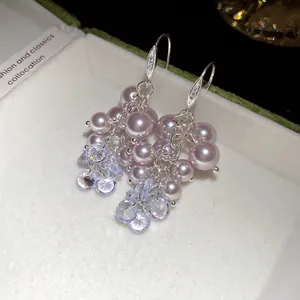 Close-up of French vintage drop earrings with lavender pearls and shimmering crystals.