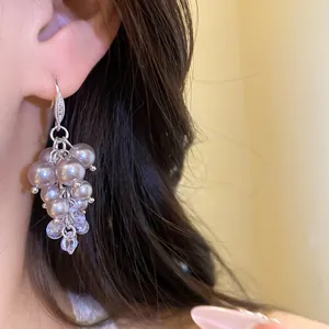 Close-up view of elegant French vintage pearl and zircon tassel drop earrings for women.