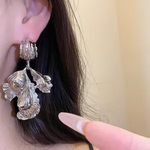 Detailed view of vintage silver metallic leaf pendant earring with textured finish