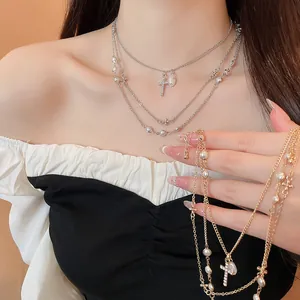 Primo piano di un'elegante collana a strati con perle e pendenti a croce di strass.