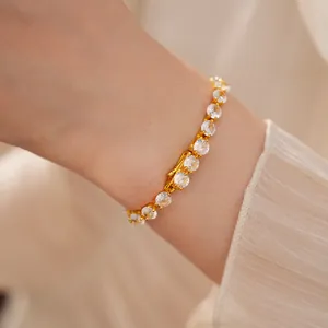 Detail of a 14k gold-plated bracelet with shimmering cubic zirconia stones on a wrist