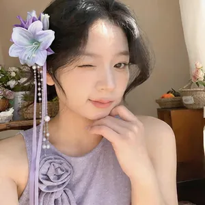 Elegant purple lily hair clip with faux pearl tassels and ribbon on an Asian model